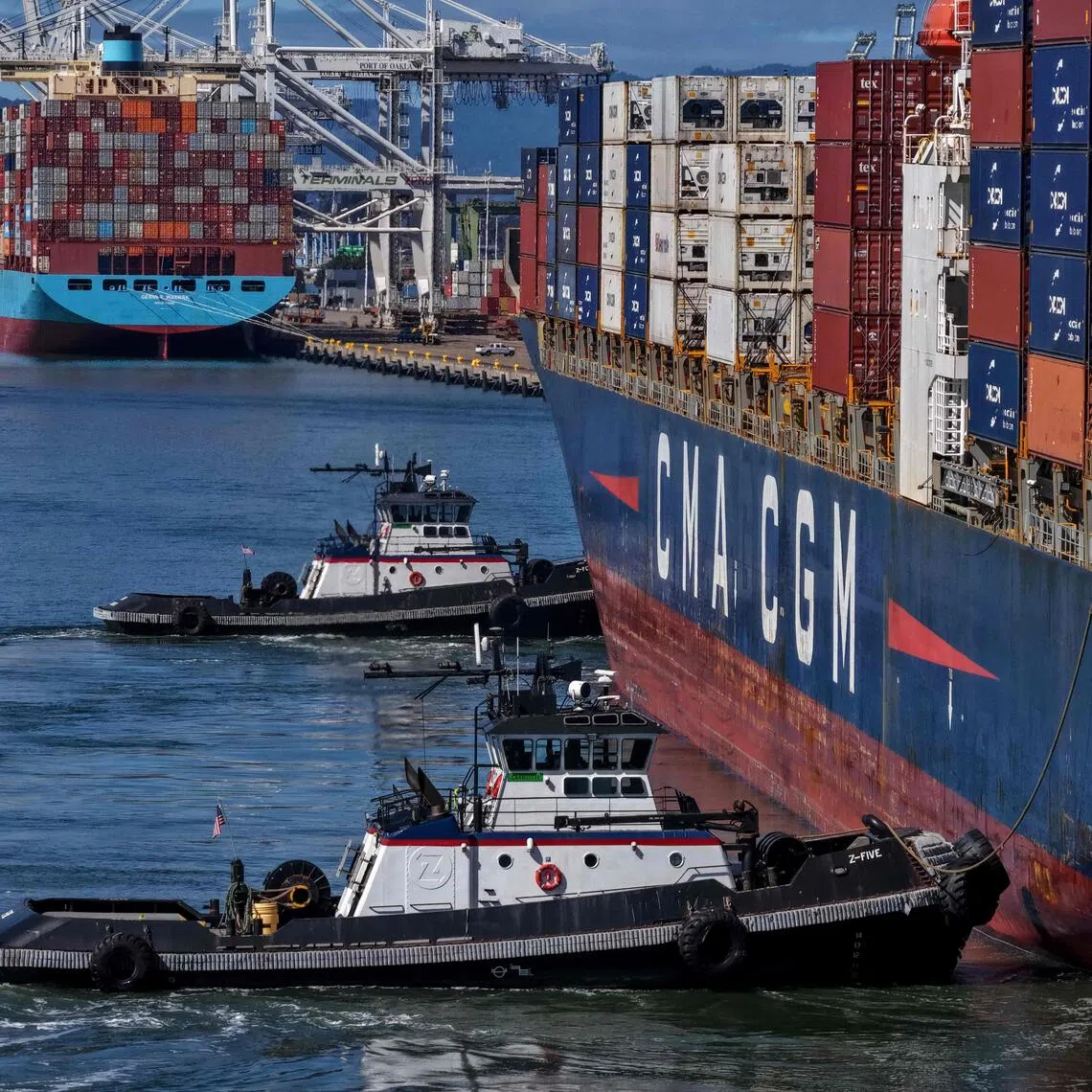 OAKLAND, CALIFORNIA - OCTOBER 10: In an aerial view, tugboats assist a container ship as it arrives at the Port of Oakland on October 10, 2025 in Oakland, California. U.S. President Donald Trump is threatening to impose a massive increase of tariffs on Chinese imports in response to China's announcement of new export controls on rare earths. China controls an estimated 70% of the global supply of rare earths minerals.   Justin Sullivan/Getty Images/AFP (Photo by JUSTIN SULLIVAN / GETTY IMAGES NORTH AMERICA / Getty Images via AFP)