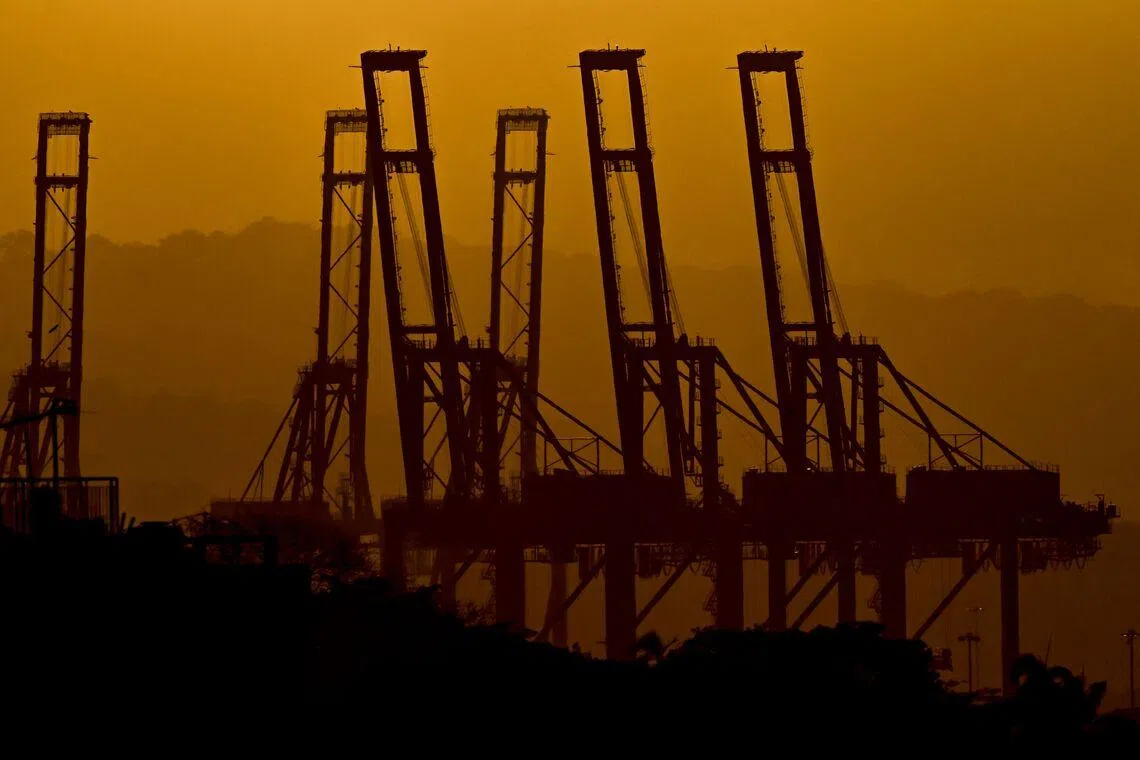 The silhouettes of the container cranes in the Port of Balboa are seen during sunset at the entrance to the Panama Canal in Panama City, on Feb 24, 2026. 
