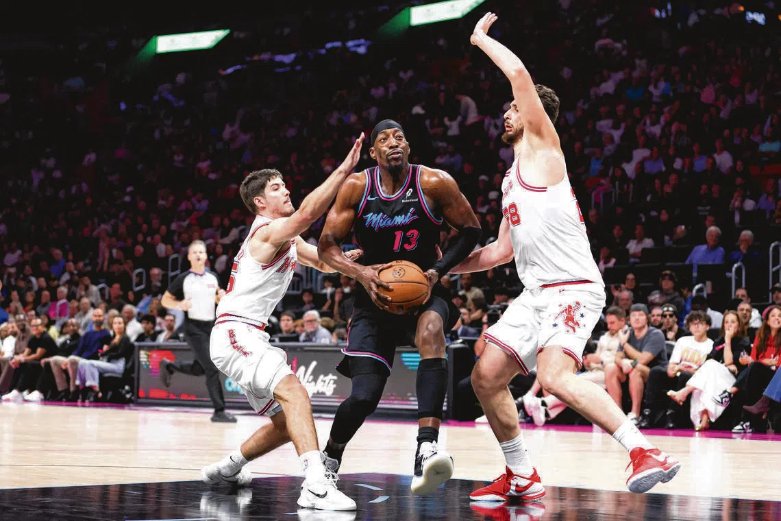 Bam Adebayo (centre) driving against Reed Sheppard (No. 15) and Alperen Sengun (No. 28) of the Houston Rockets on Feb 28, in Miami, Florida.