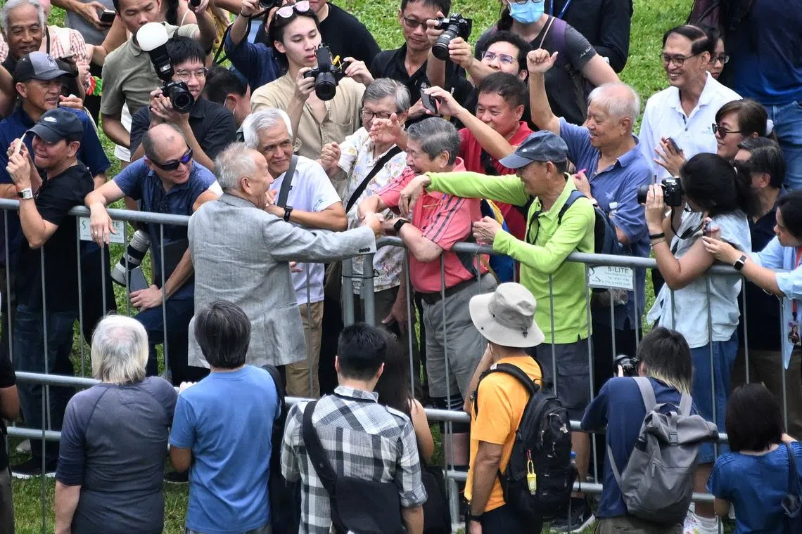 Supporters of Ng Kok Song reach out to shake his hand.