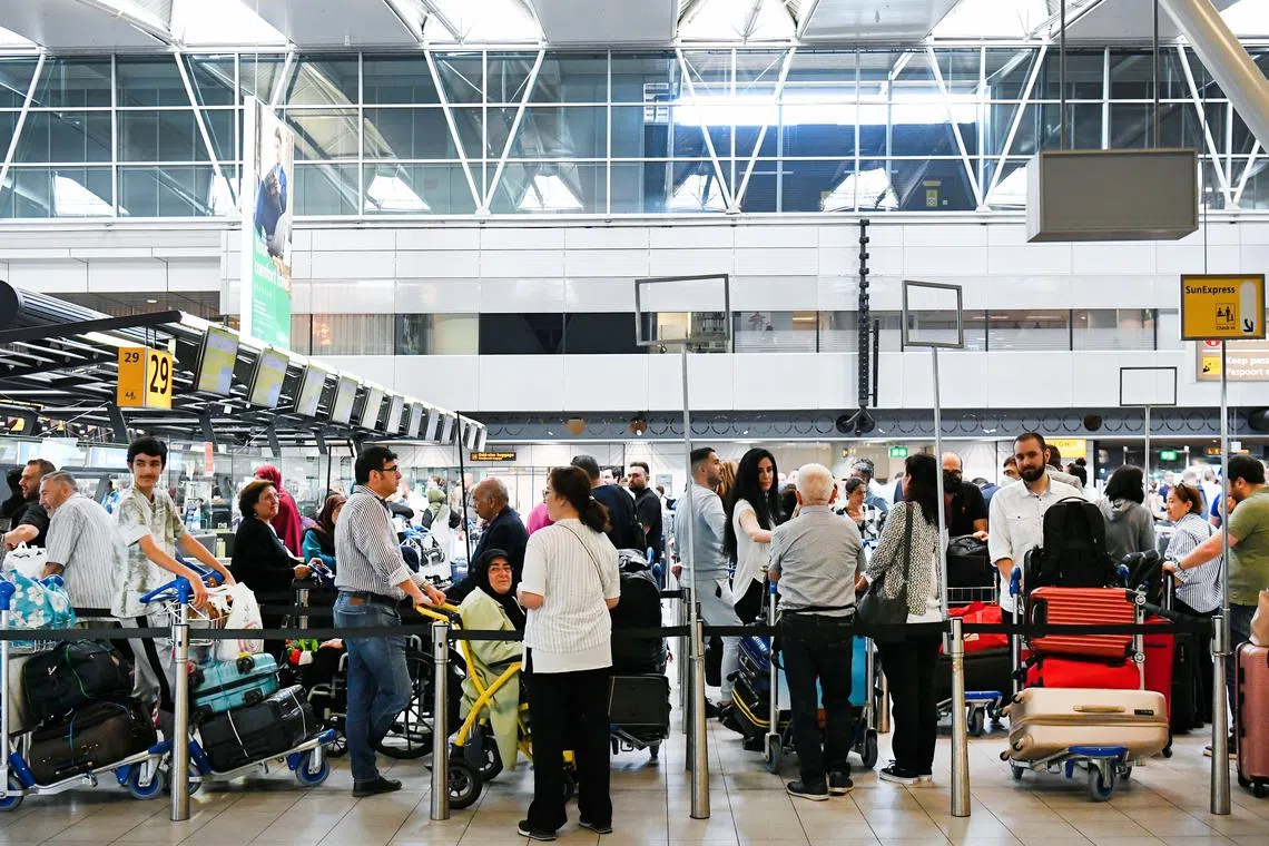 FILE PHOTO: People wait in lines at Schiphol Airport in Amsterdam, Netherlands June 16, 2022. REUTERS/Piroschka van de Wouw/File Photo