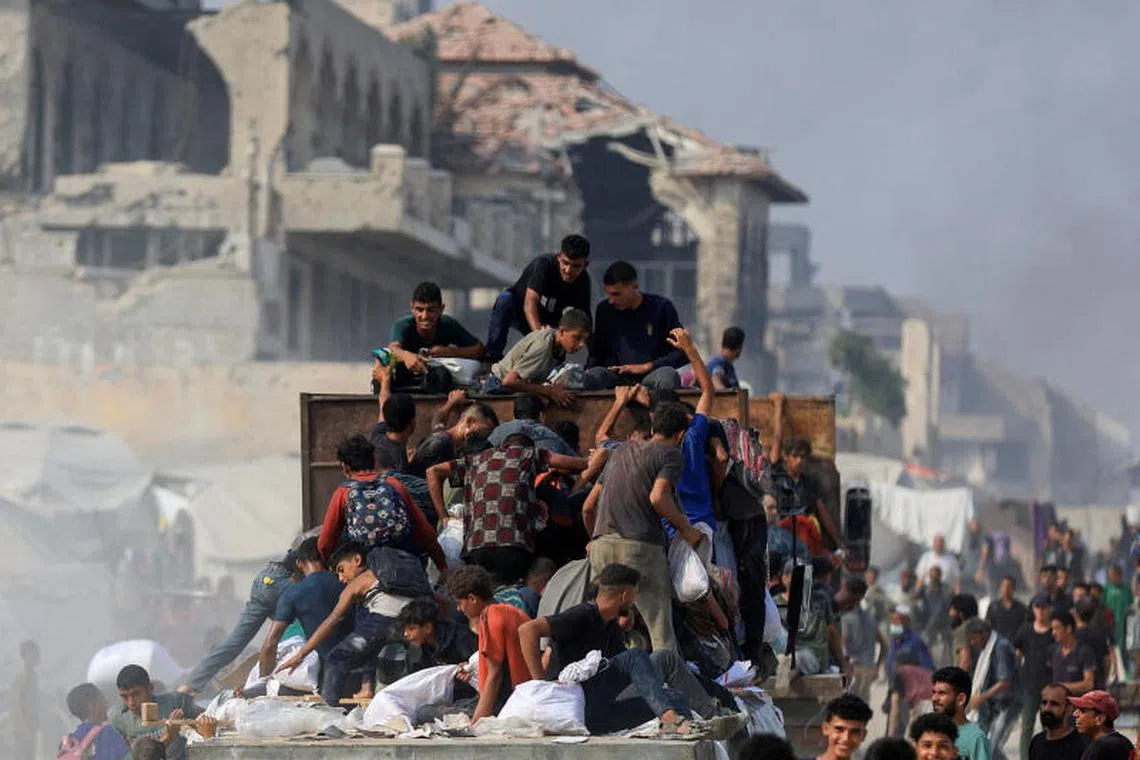 Palestinians ride on a truck as they collect aid supplies that entered Gaza through Israel, in Beit Lahia, in the northern Gaza Strip August 10, 2025. REUTERS/Dawoud Abu Alkas TPX IMAGES OF THE DAY