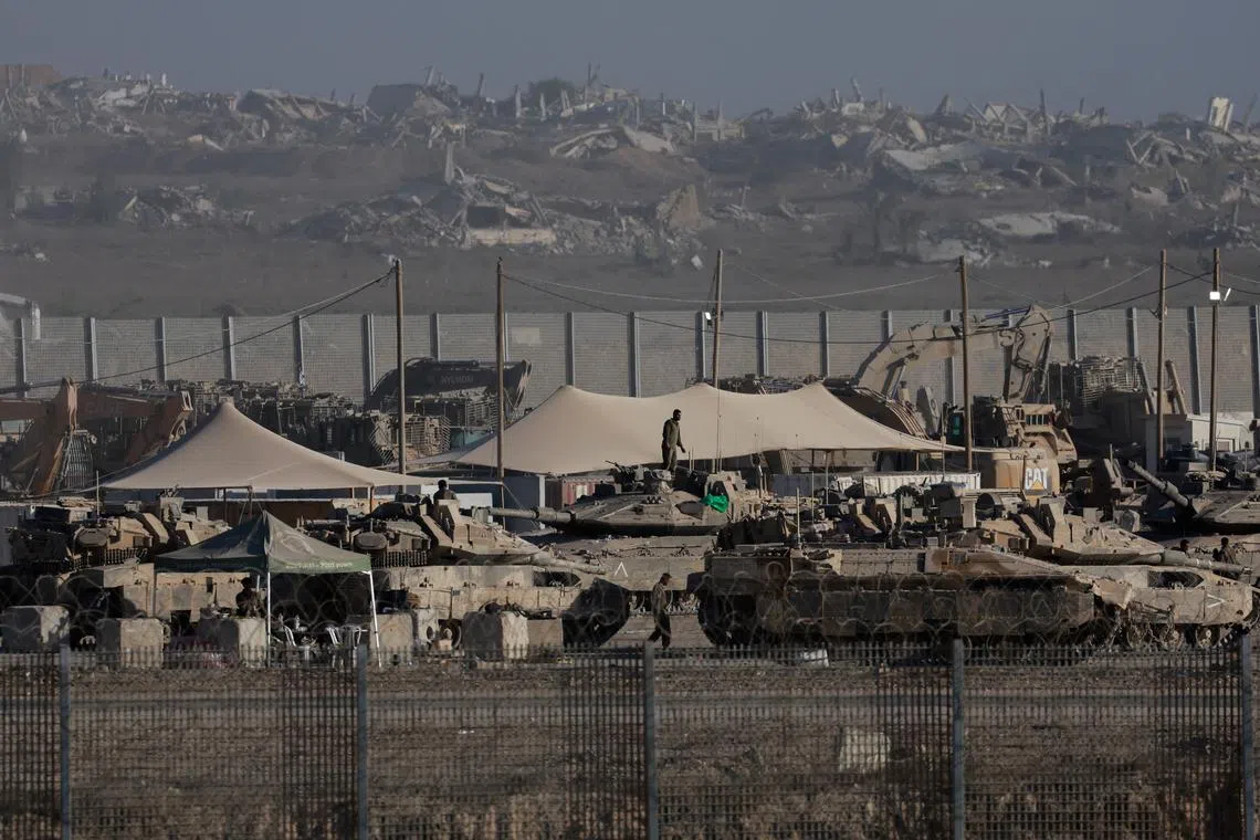 Israel Defense Forces personnel gather near military vehicles and heavy machinery, along the border with Gaza, as seen from the Israeli side, September 3, 2025. REUTERS/Ammar Awad