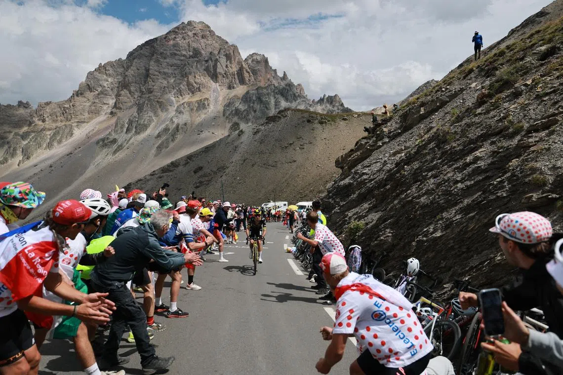 Cycling - Tour de France - Stage 20 - Le Bourg d'Oisans to Alpe d'Huez - Le Bourg d'Oisans, France - July 25, 2026 General view of cyclists in action as spectators cheer during stage 20 REUTERS/Stephanie Lecocq