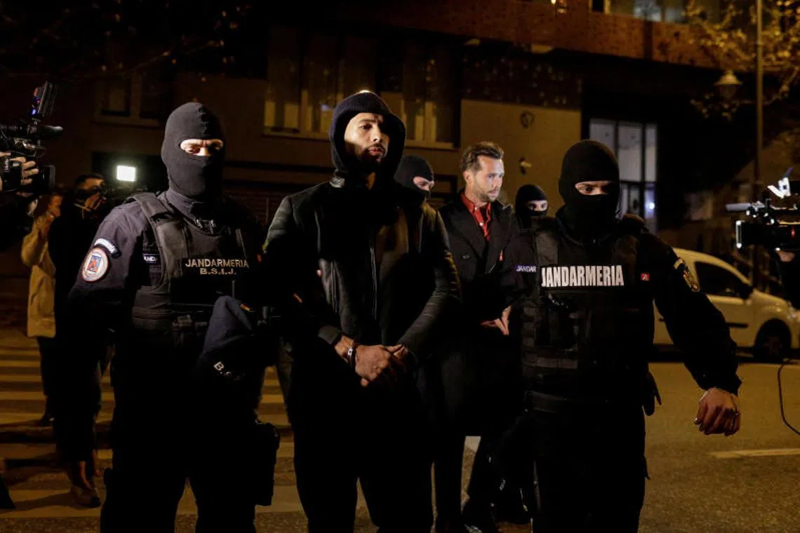 Andrew Tate escorted by police officers outside the headquarters of the Directorate for Investigating Organized Crime and Terrorism in Bucharest, Romania, on Dec 29, 2022.
