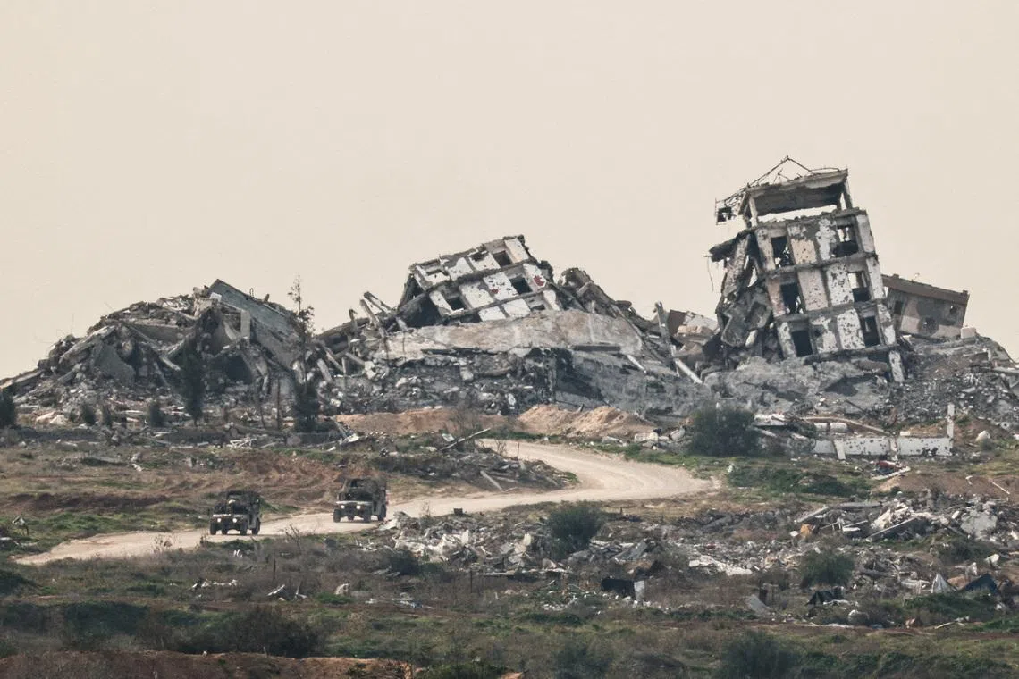 FILE PHOTO: Israeli military vehicles drive past destruction in Gaza, as seen from the Israeli side of the Israel-Gaza border in southern Israel, January 21, 2026. REUTERS/Amir Cohen/File Photo