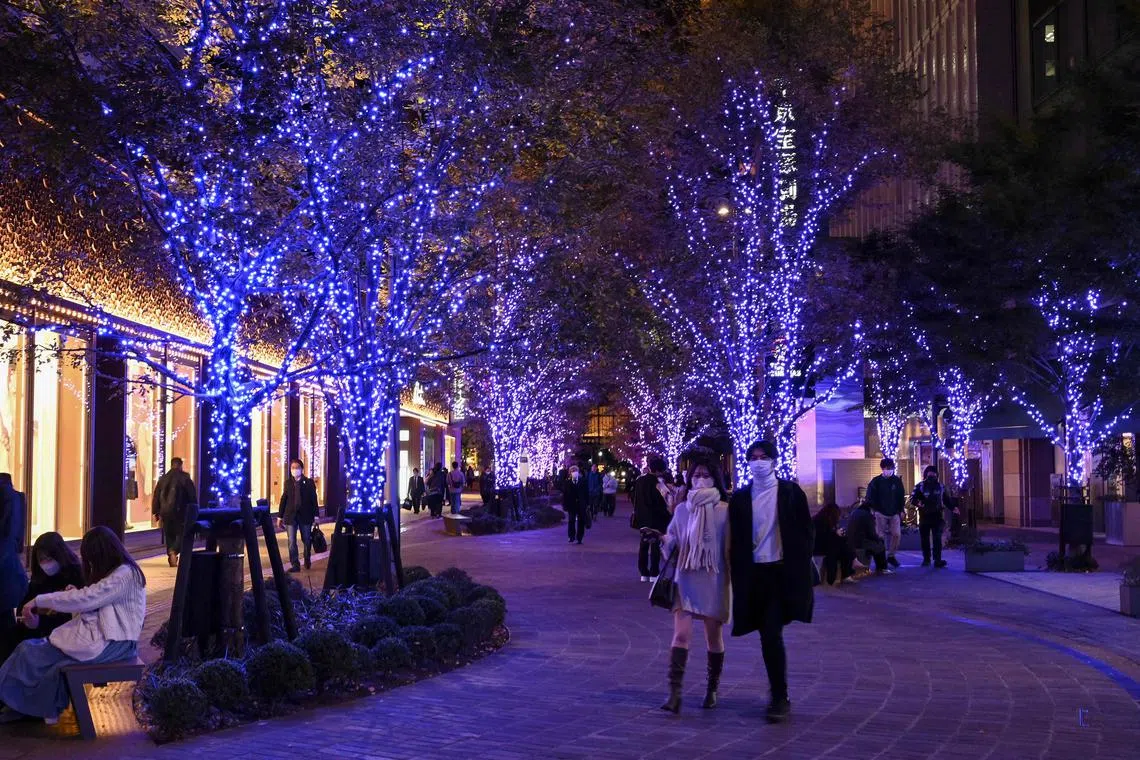 People walk along trees covered with decorative lights set up in the run-up to the Christmas season in downtown Tokyo. Tokyo’s Governor Yurio Koike is encouraging the city’s residents to wear a turtleneck to keep warm and save energy.
