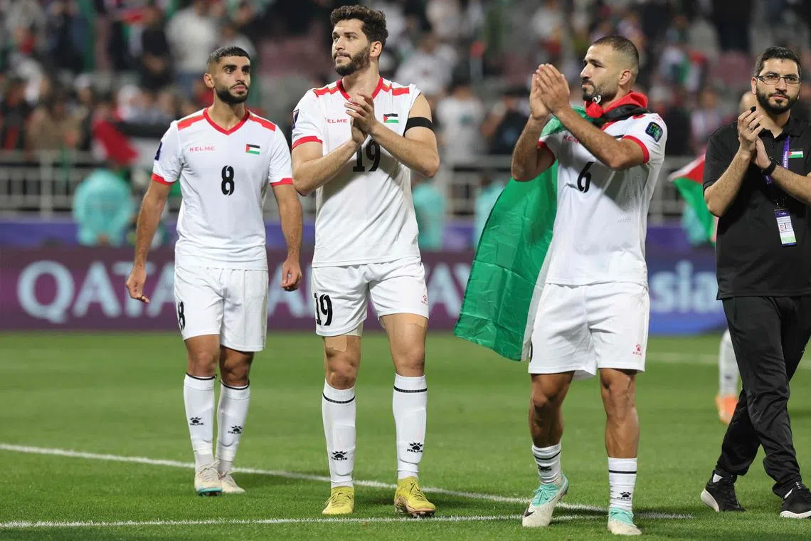 Palestine's players greet their supporters after the 3-0 Asian Cup win over Hong Kong.