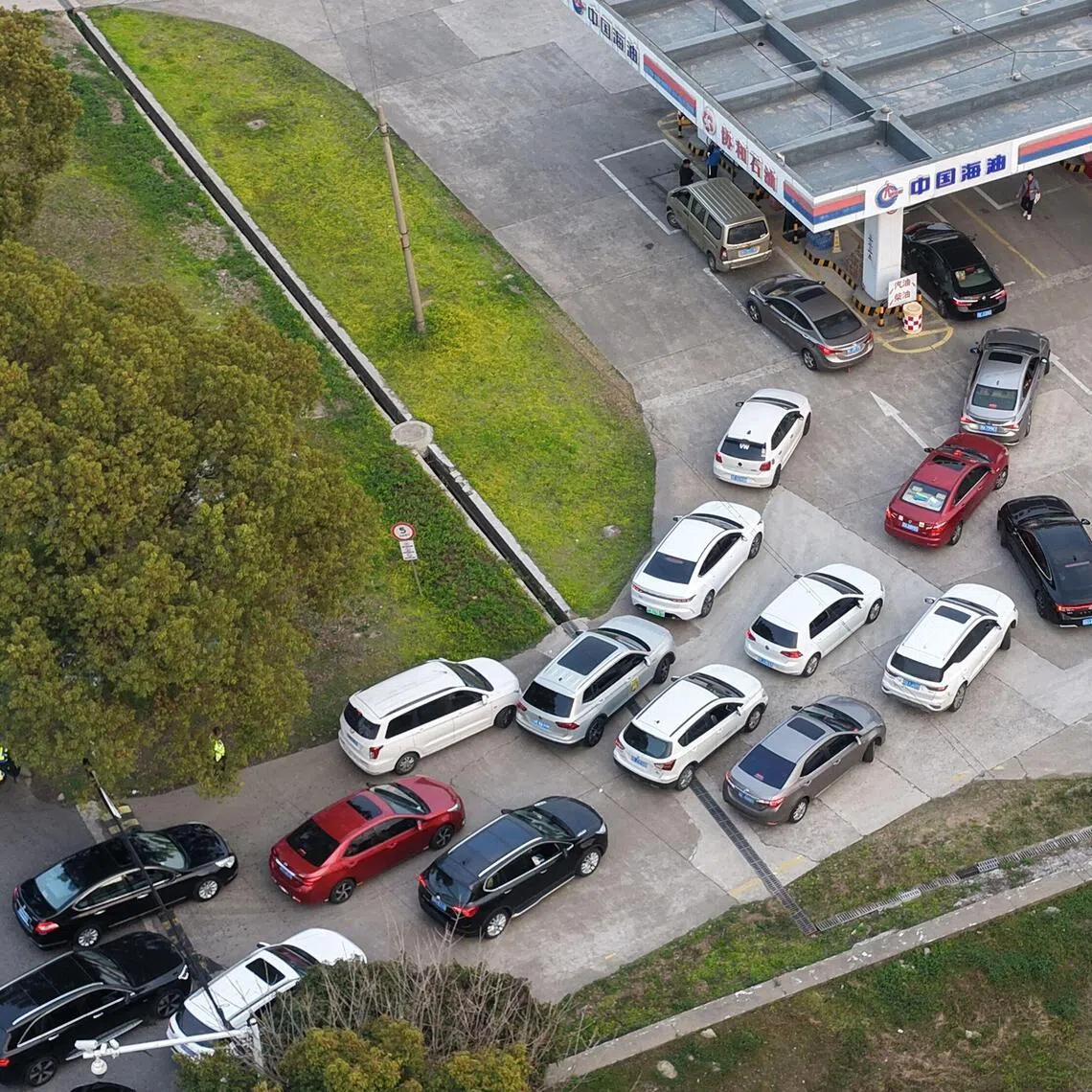 Motorists queue to fill their tanks ahead of a petrol price adjustment expected on March 23, at a petrol station in Suzhou, in China’s eastern Jiangsu province on March 22, 2026. (Photo by CN-STR / AFP) / China OUT