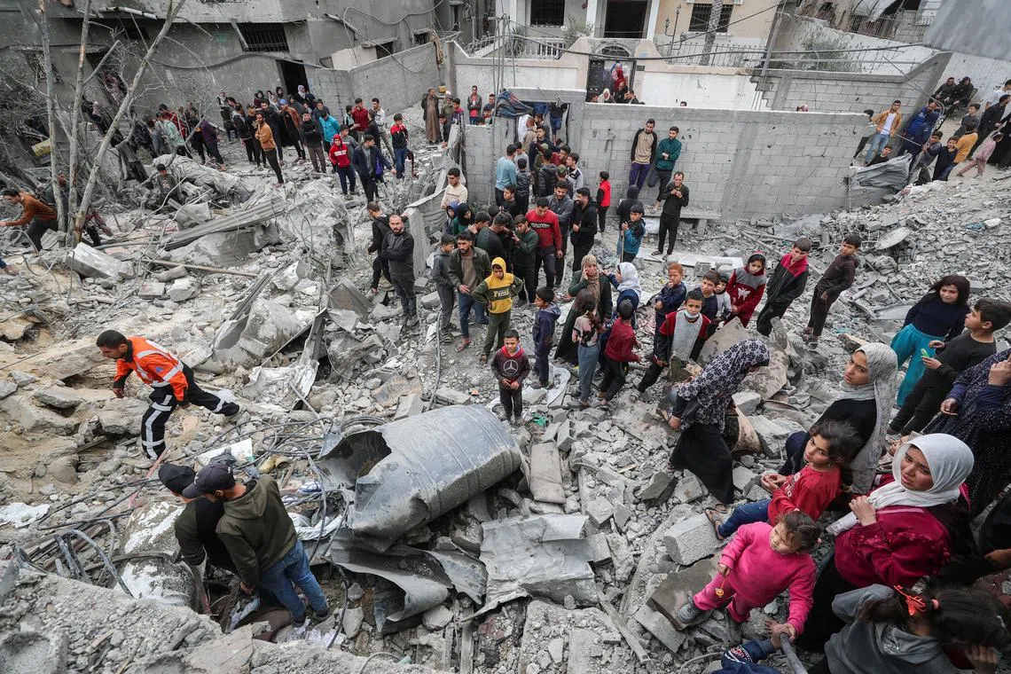 FILE PHOTO: Palestinians gather at the site of an Israeli strike on a house as rescuers attempt to remove casualties from under the rubble, in Jabalia in the northern Gaza Strip April 13, 2025. REUTERS/Mahmoud Issa/File Photo
