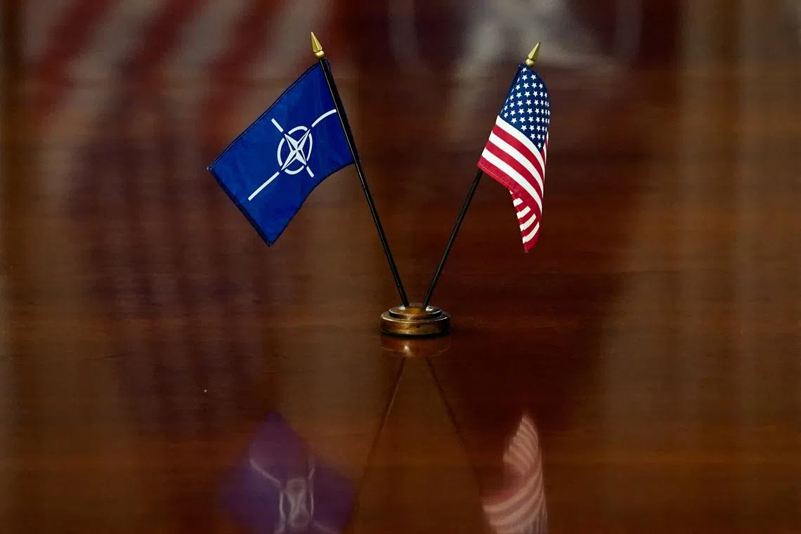 FILE PHOTO: NATO and U.S. flags are set on the table as U.S. Defense Secretary Pete Hegseth and NATO Secretary General Mark Rutte meet at the Pentagon in Washington, D.C., U.S., April 24, 2025. REUTERS/Nathan Howard
