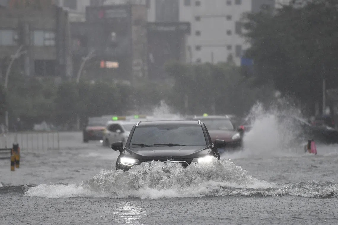 Vehicles driving through a flooded area in Haikou, Hainan Province, China, on July 20, 2025. Typhoon Wipha made landfall near Jiangmen City in south China's Guangdong Province around 5:50 p.m., according to the Guangdong provincial meteorological observatory. 