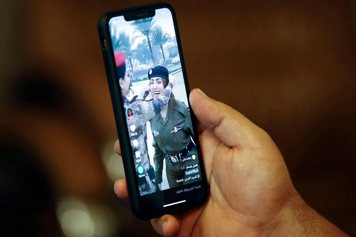 An Iraqi man shows a post on social media platform with a picture of TikTok celebrity Assal Hossam, who has been jailed by the authorities.