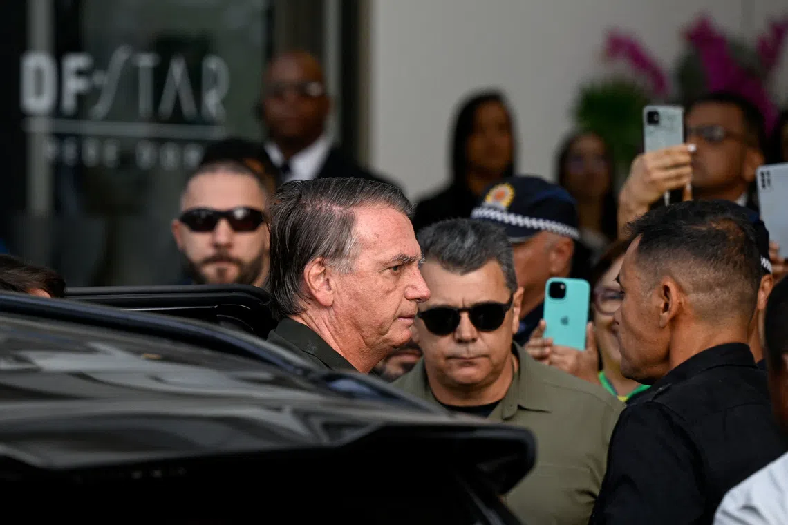 Former Brazilian President Jair Bolsonaro arrives at a hospital to undergo a skin surgery procedure, authorized by Supreme Court Justice Alexandre de Moraes, leaving the house arrest after being convicted by a Supreme Court majority of plotting a coup to remain in power after losing the 2022 election, in Brasilia, Brazil, September 14, 2025. REUTERS/Mateus Bonomi