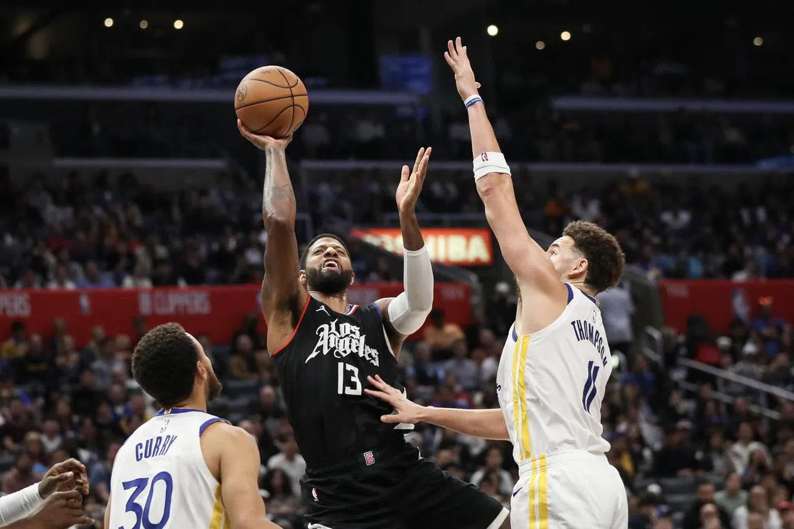 Paul George of the LA Clippers shoots the ball defended by Klay Thompson of the Golden State Warriors in the fourth quarter at Crypto.com Arena.