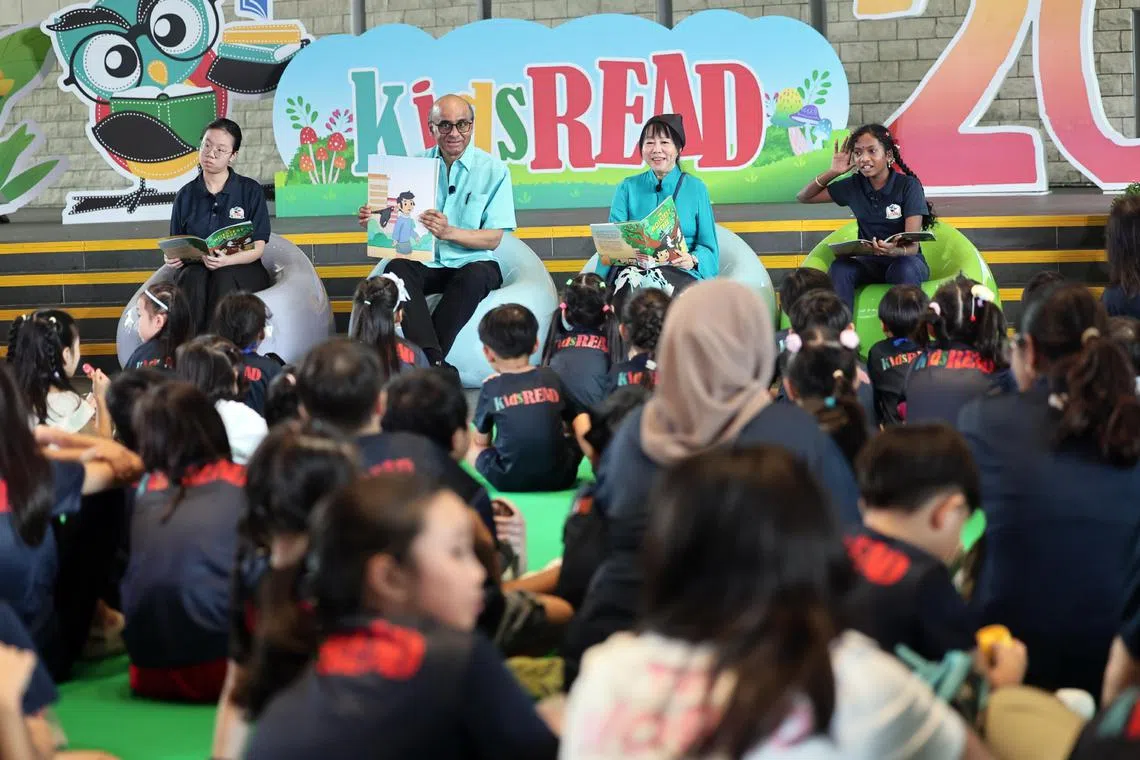 President Tharman Shanmugaratnam and Ms Jane Ittogi reading a story to participants during an event at the National Library Building on Aug 31 to mark 20 years of kidsRead.