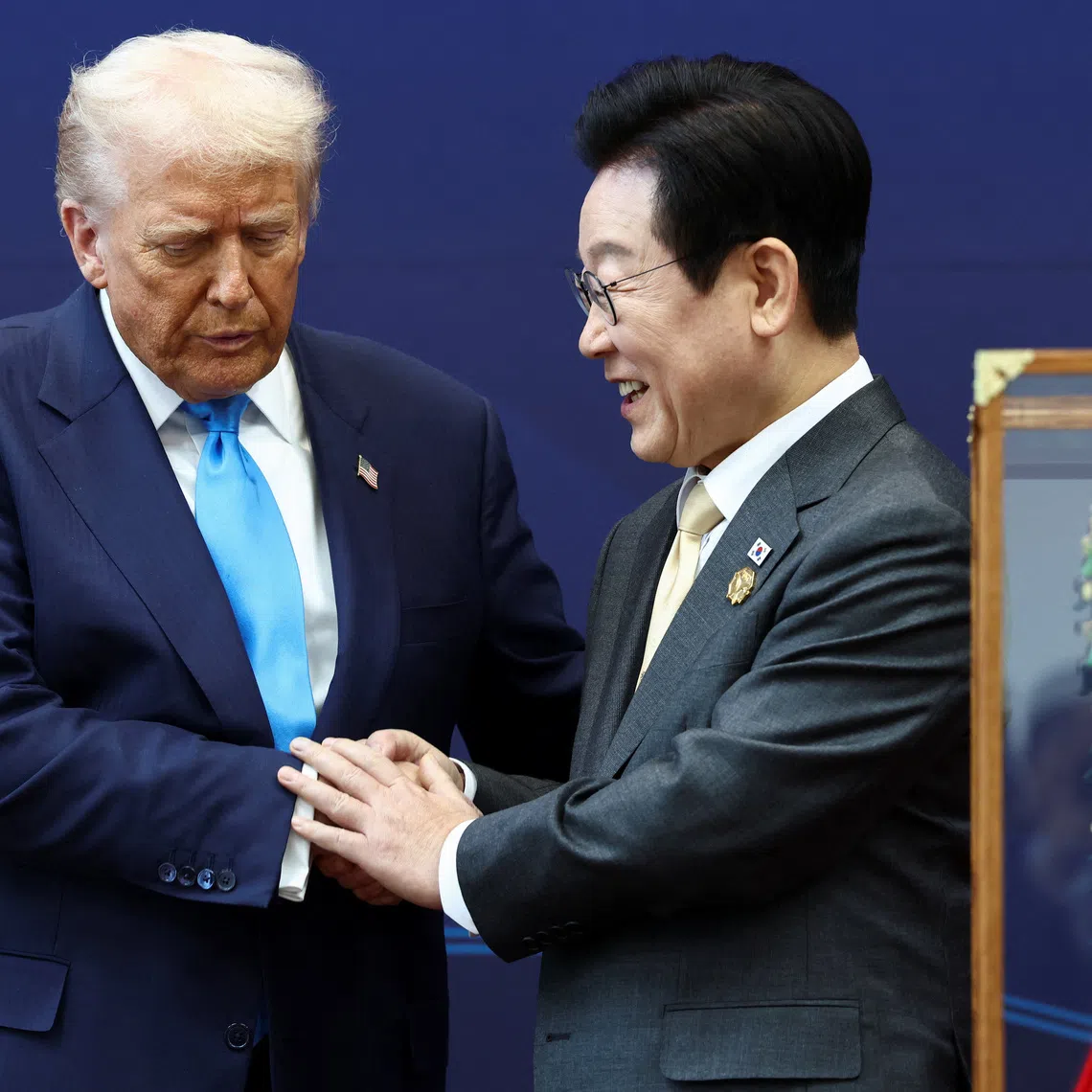U.S. President Donald Trump is presented with the \"Grand Order of Mugunghwa\" (not pictured) and a replica gold crown during a meeting with South Korean President Lee Jae Myung on the sidelines of the Asia-Pacific Economic Cooperation (APEC) leaders' summit in Gyeongju, South Korea, October 29, 2025. REUTERS/Evelyn Hockstein