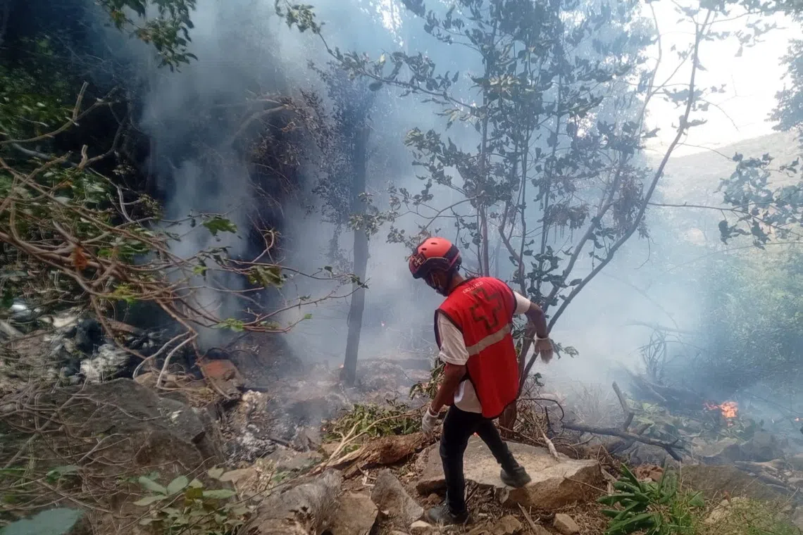 A rescue official works at the site of a tourist helicopter crash that caused multiple casualties, according to the police, in Samburu County, Kenya, August 19, 2026. Kenya Red Cross/Handout via REUTERS