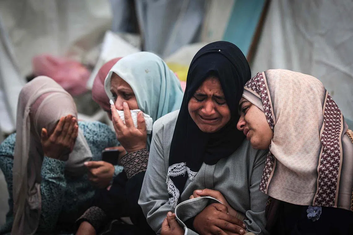 Palestinians mourning their relatives, killed in an overnight Israeli strike on the Al-Maghazi refugee camp, during a mass funeral at the Al-Aqsa hospital in Deir Al-Balah, in the southern Gaza Strip, on Dec 25, 2023, amid ongoing battles between Israel and the Palestinian militant group Hamas. 