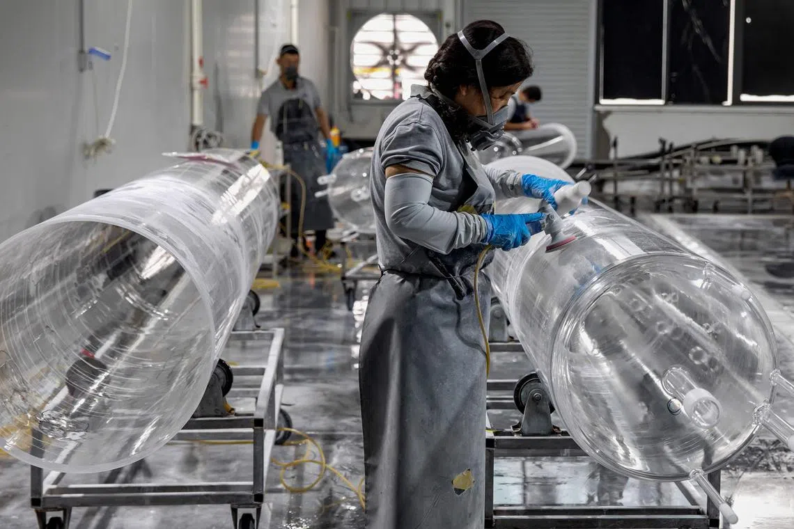 Employees working on a quartz glass tube production line at a factory in Lianyungang, in eastern China's Jiangsu province.