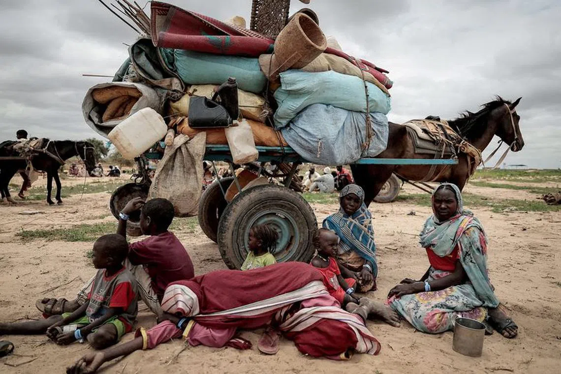FILE PHOTO: A Sudanese family who fled the conflict in Murnei in Sudan's Darfur region, sit beside their belongings while waiting to be registered by UNHCR upon crossing the border between Sudan and Chad in Adre, Chad, July 26, 2023.      REUTERS/Zohra Bensemra/File Photo