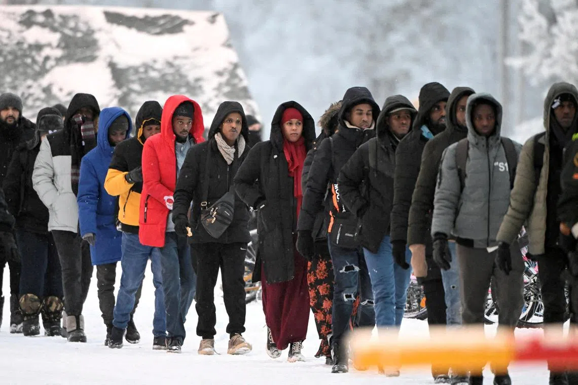 FILE PHOTO: A group of migrants arrive to the international border crossing at Salla, northern Finland, November 23, 2023.  Lehtikuva/Jussi Nukari via REUTERS/File Photo