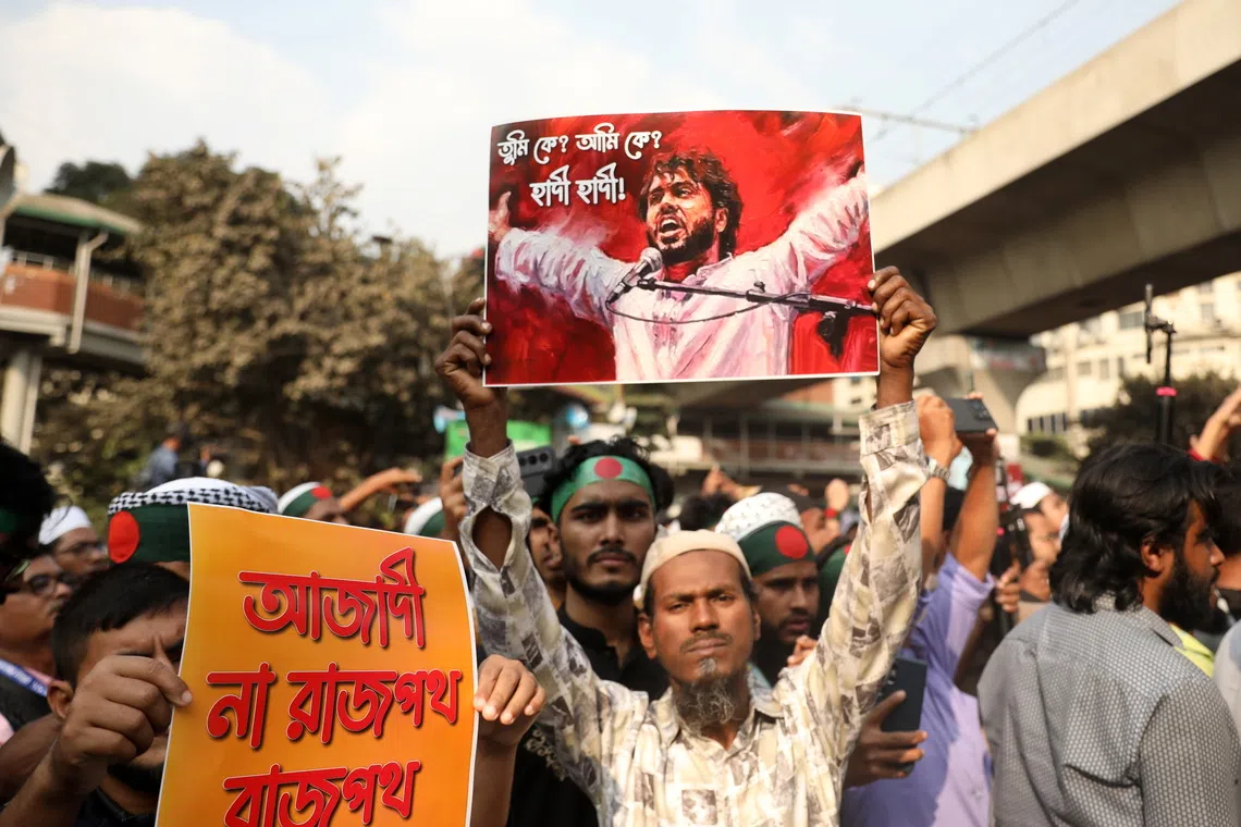 A protester with a photo depicting Mr Sharif Osman Hadi during a demonstration in Dhaka on Dec 19.