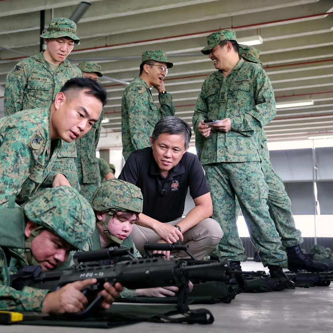 Defence Minister Chan Chun Sing (in black shirt) observing a weapon refresher for servicemen during a mobilisation exercise at Selarang Camp on July 19.
