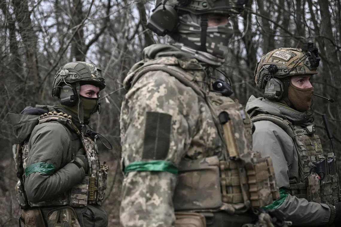 Members of the Ukrainian commando unit wait in the woods near Bakhmut, in Ukraine's Donbas region, on March 15, 2023.