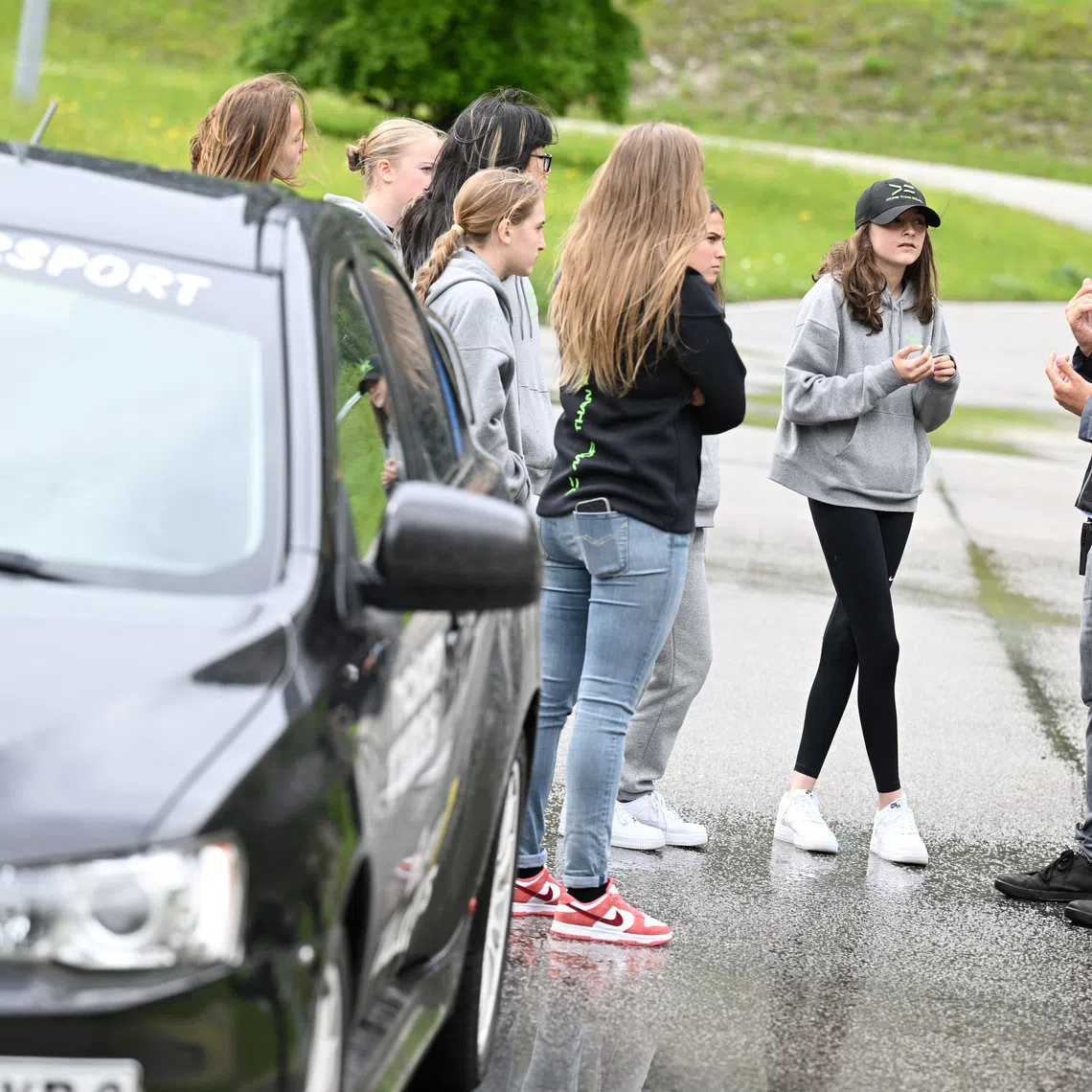 Participants from the More Than Equal Global Driver Development programme with a coach at the training racetrack in Saalfelden, Austria in 2024.