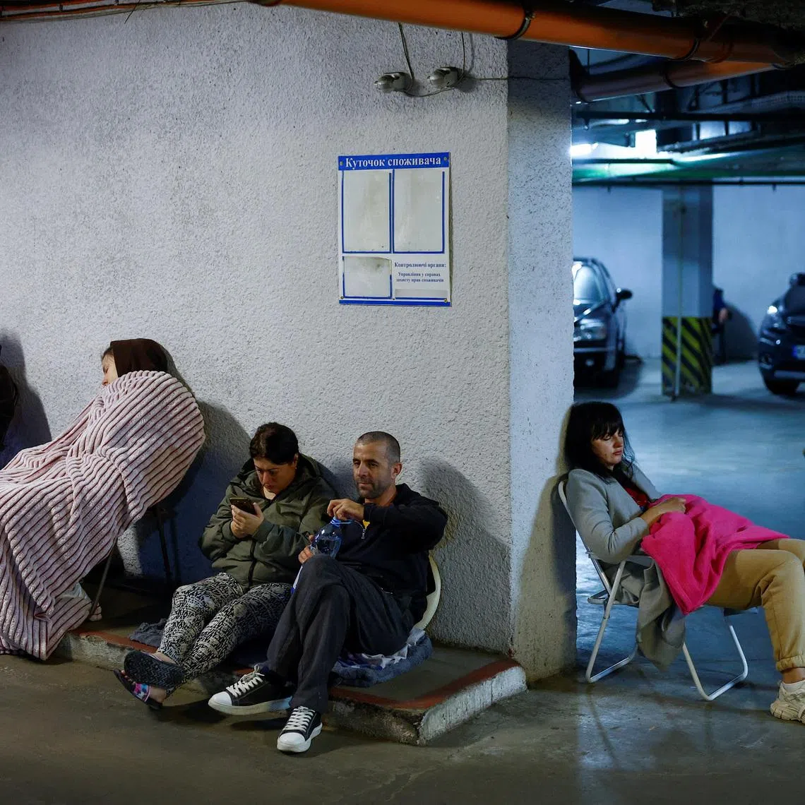 Residents take shelter inside an underground parking during Russian missile and drone strikes in Kyiv on June 15.