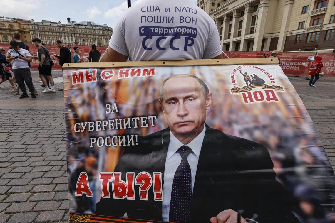 epa10717460 A member of the National Liberation Movement (NLM) holds a a poster showing Russian President Vladimir Putin reading 'The US and NATO went out of the territory of the USSR. We stand with him for the sovereignty of Russia. And you?' during a single picket in support of the Russian president on Manezhnaya Square, outside the Kremlin in Moscow, Russia, 29 June 2023. On 24 June, counter-terrorism measures were enforced in Moscow and other Russian regions after private military company (PMC) Wagner Group chief Yevgeny Prigozhin claimed that his troops had occupied the building of the headquarters of the Southern Military District in Rostov-on-Don, demanding a meeting with Russia's defense chiefs. Belarusian President Lukashenko, a close ally of Putin, negotiated a deal with Wagner chief Prigozhin to stop the movement of the group's fighters across Russia, the press service of the President of Belarus reported. Prigozhin announced that Wagner fighters were turning their columns around and going back in the other direction, returning to their field camps.  EPA-EFE/SERGEI ILNITSKY  EPA-EFE/SERGEI ILNITSKY