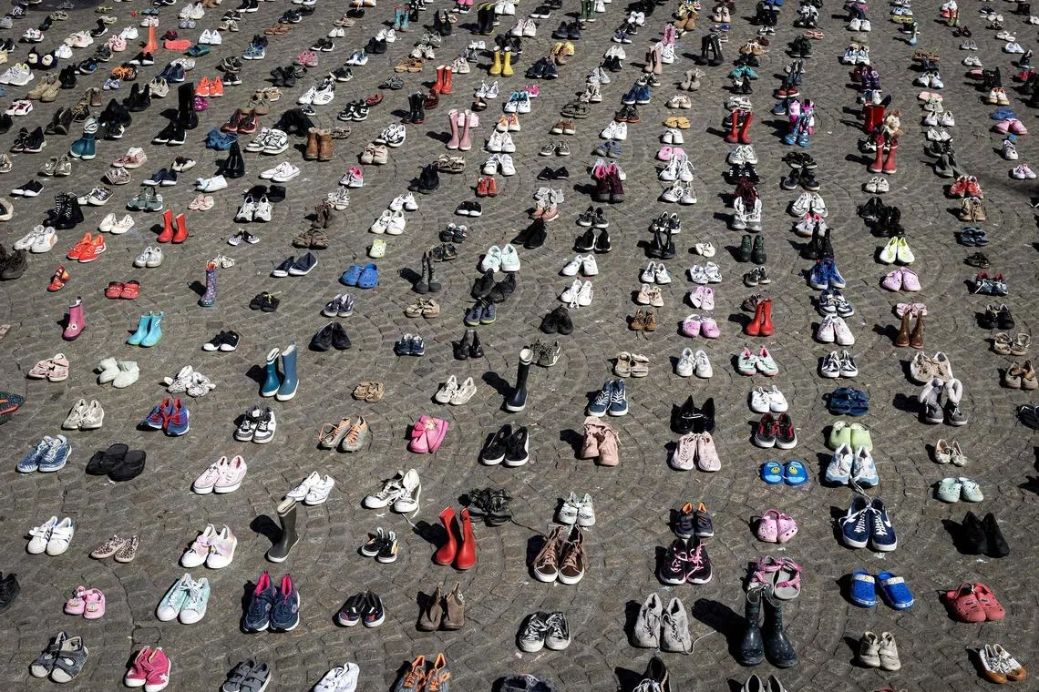 TOPSHOT - A photo shows children's shoes layed out on Dam Square during a memorial protest organised by Plant an Olive Tree group for child victims in Gaza, in Amsterdam, on April 12, 2026. (Photo by Ramon van Flymen / ANP / AFP) / Netherlands OUT