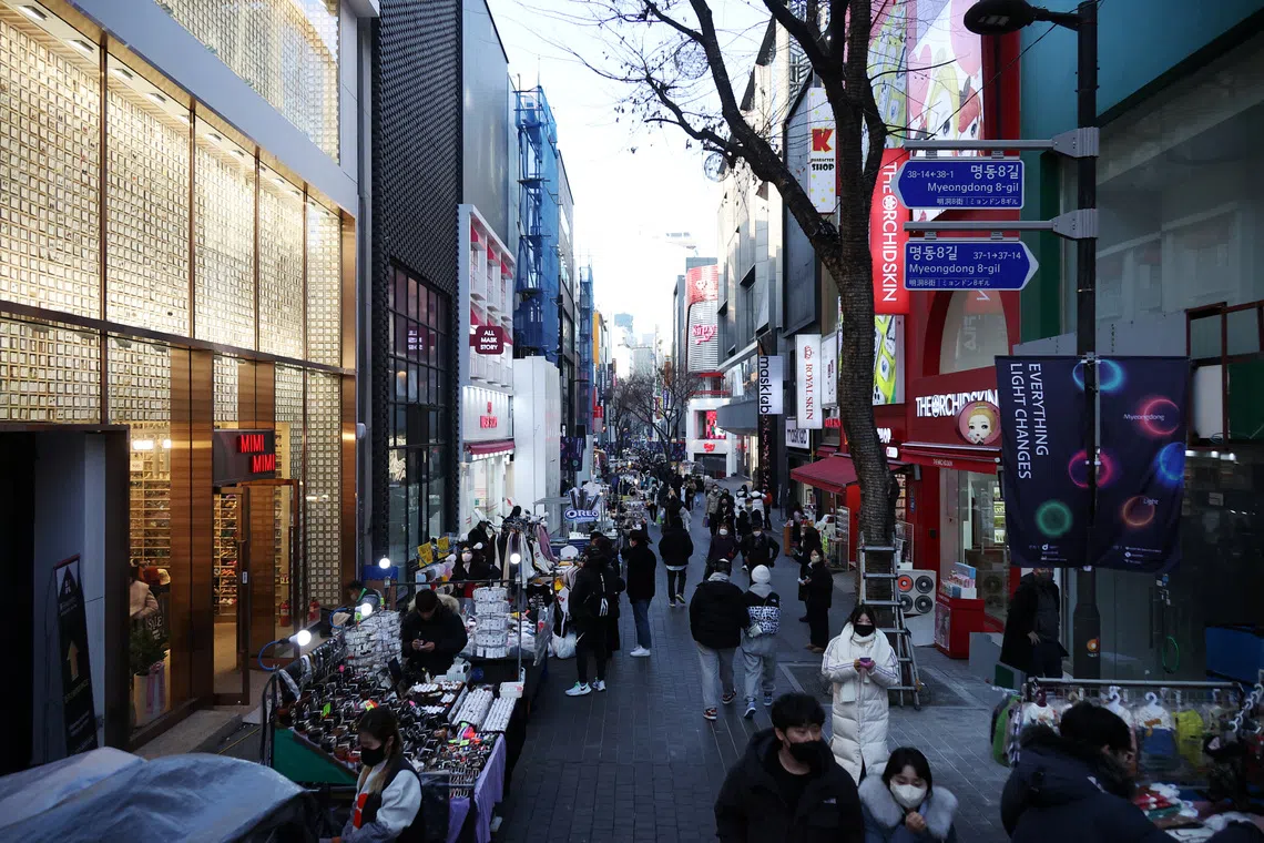 FILE PHOTO: Street vendors (L) wait for customers at Myeongdong shopping district in Seoul, South Korea, January 9, 2023.    REUTERS/Kim Hong-Ji/ File Photo