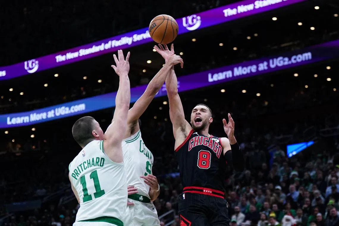 Chicago Bulls guard Zach LaVine shoots against Boston Celtics guards Derrick White and Payton Pritchard in the second half at TD Garden.