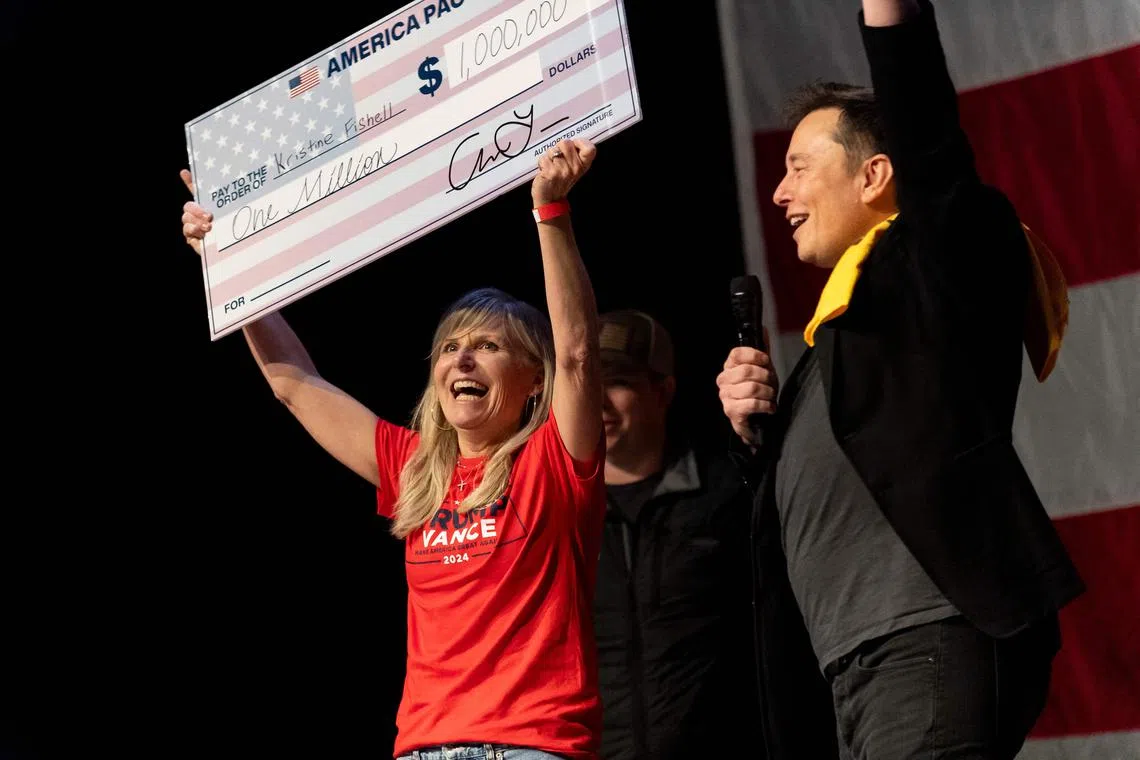 Mr Musk (right) awarded Ms Kristine Fishell (left) with a US$1 million cheque in Pittsburgh, Pennsylvania on Oct 20, 2024. 