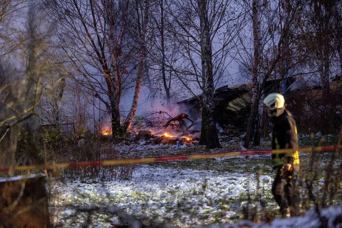 FILE PHOTO: Rescuer walks past DHL cargo plane wreckage, at the crash site near Vilnius International Airport, Lithuania November 25, 2024. Lukas Balandis/BNS via REUTERS/File Photo