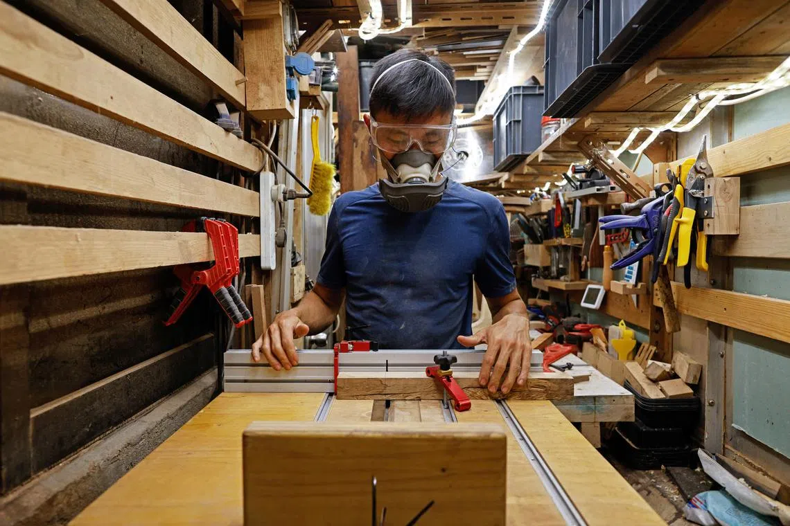 Craftsman Jesse Yu, 32, works in a workshop in the alley behind his apartment, on Peng Chau island, in Hong Kong, China September 14, 2022. "I enjoy doing woodwork because of the freedom," Yu said.     REUTERS/Tyrone Siu    SEARCH "PENG CHAU SIU" FOR THIS STORY. SEARCH "WIDER IMAGE" FOR ALL STORIES.