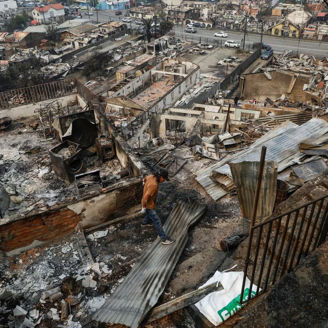 A person inspects a destroyed building, in the aftermath of a forest fire in the Biobio region, where multiple wildfires prompted emergency evacuations, in Concepcion, Chile January 19, 2026. REUTERS/Juan Gonzalez