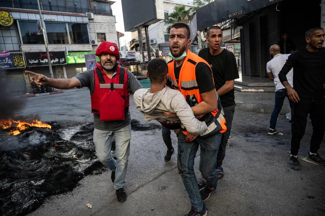 An injured man is carried away after being reportedly shot by Israeli soldiers in the occupied West Bank city of Jenin.
