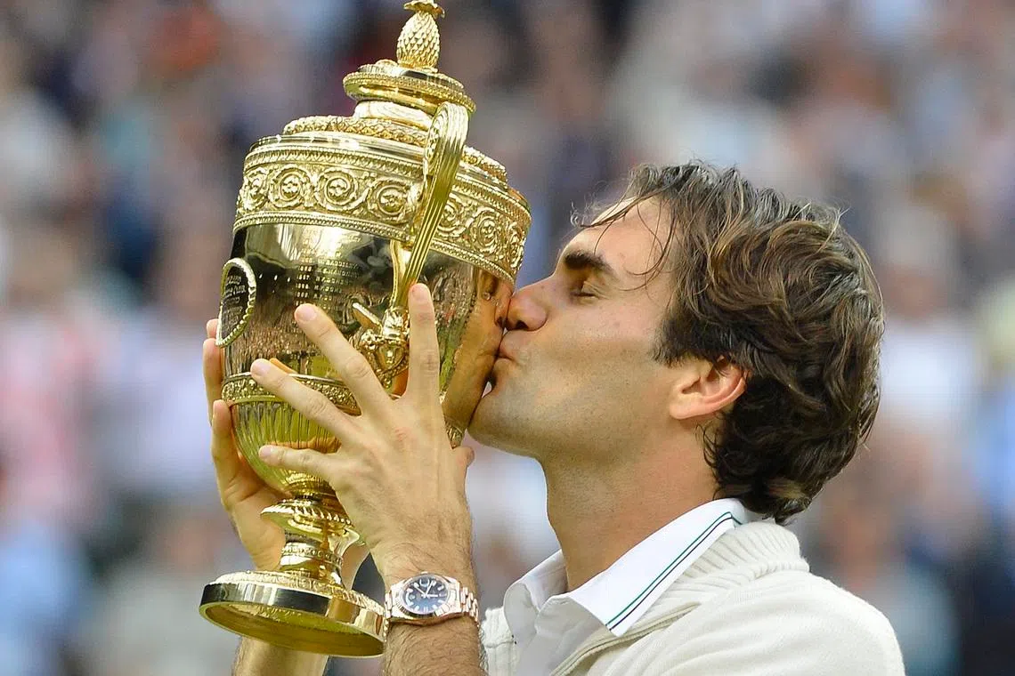 Roger Federer of Switzerland kisses the winner's trophy after defeating Andy Murray of Britain in their men's singles final tennis match at the Wimbledon Tennis Championships in London July 8, 2012. REUTERS/Toby Melville/File Photo
