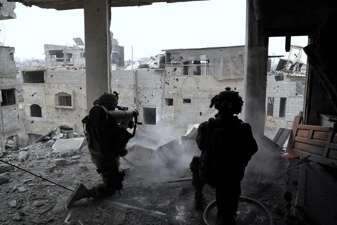 FILE PHOTO: Israeli soldiers fire during an operation against Palestinian Islamist group Hamas, in a location given as Gaza in this handout image released on November 16, 2023. Israel Defense Forces/Handout via REUTERS/File photo