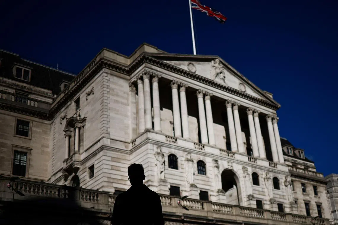 A pedestrian crosses the streets in front of The Bank of England illuminated by a ray of sunlight, in central London, on February 12, 2024. (Photo by HENRY NICHOLLS / AFP)