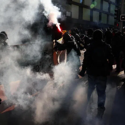 People holding banners and flares during a protest in Geneva, Switzerland, against the upcoming G-7 summit, on June 14, 2026.