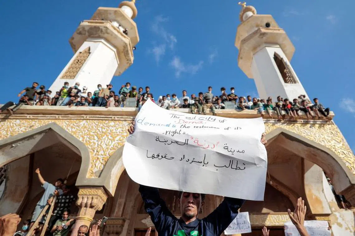 People who survived the deadly storm that hit Libya, protest outside the Al Sahaba mosque against the government in Derna, Libya September 18, 2023. The sign reads: \"The sad city of Derna demands its rights\". REUTERS/Zohra Bensemra