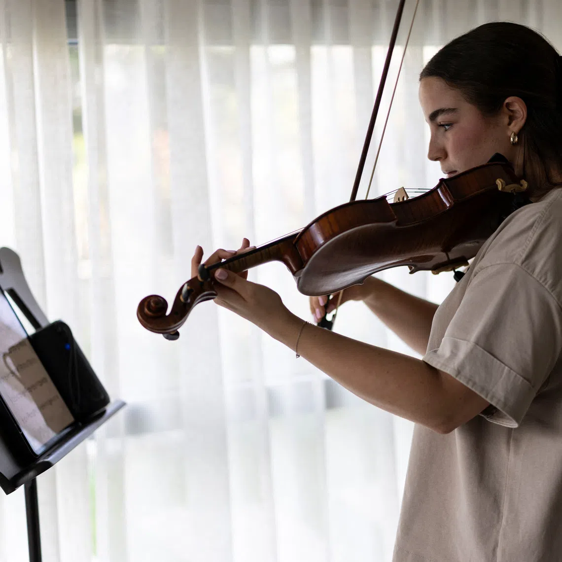 Agam Berger, 22, a former hostage, practices the violin ahead of performances at two memorial ceremonies for the third anniversary of October 7 at her home in Holon, Israel, September 17, 2026. Agam Berger was abducted from the Nahal Oz military base in southern Israel during the deadly Hamas-led attack on October 7, 2023, where she was serving as a surveillance soldier, and taken hostage to Gaza; she was held for 482 days before being released on January 30, 2025. REUTERS/Shir Torem