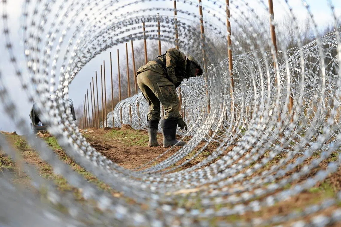 Soldiers build razor wire fence on Poland's border with Russia's exclave of Kaliningrad near Bolcie, Poland November 3, 2022.