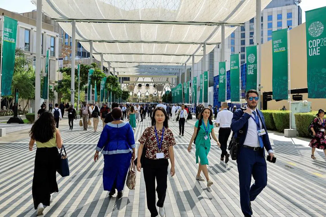 Delegates walk at the Dubai's Expo City during the United Nations Climate Change Conference (COP28) in Dubai, United Arab Emirates, December 4, 2023. REUTERS/Thaier Al-Sudani