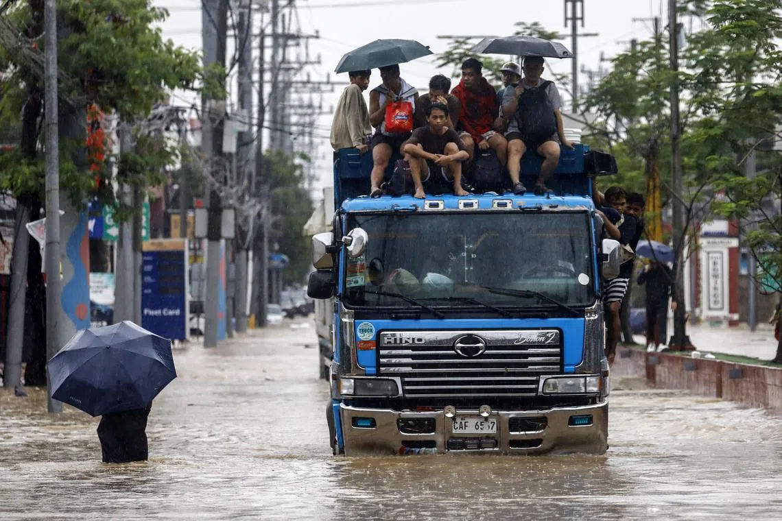 epa11579349 People ride atop a truck along a flooded road in Cainta, Rizal province, northeast of Manila, Philippines, 02 September 2024. In a report by the National Disaster Risk Reduction and Management Council (NDRRMC), two people died as tropical storm Yagi hit the Philippines. The state weather agency has warned of possible flash floods in low-lying areas and landslides in mountainous villages.  EPA-EFE/ROLEX DELA PENA