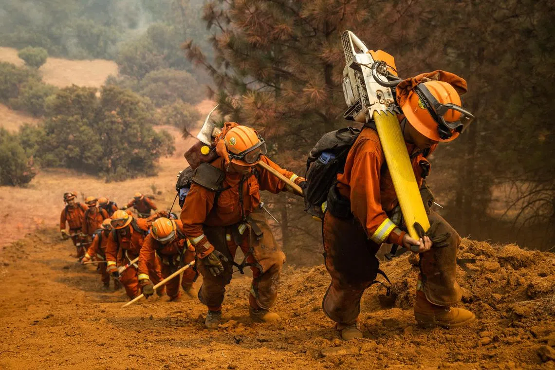 FILE --Inmate firefighters clearing a fire line on the Walbridge Fire near Healdsburg, Calif., during the LNU Complex fire, Aug. 23, 2020. Hundreds of incarcerated people are firefighting in Los Angeles. They usually make up to $10.24 a day, and receive an additional $1 for each hour that they battle the deadly blazes. (Max Whittaker/The New York Times)